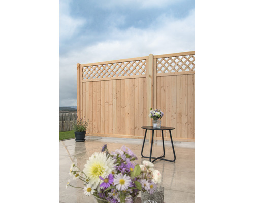 Holzzaun mit Rautenmuster auf einer Terrasse mit Blumen