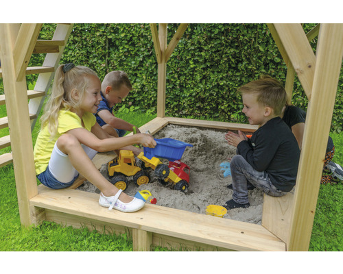 Kinder spielen im Sandkasten mit Spielzeugfahrzeugen.