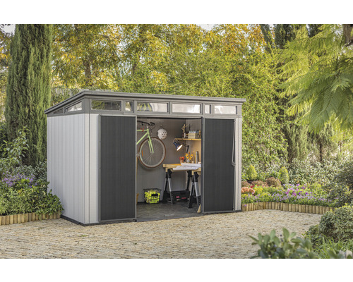 Geräumiger Gerätehaus mit geöffneten Schiebetüren und Werkstattbereich im Garten.