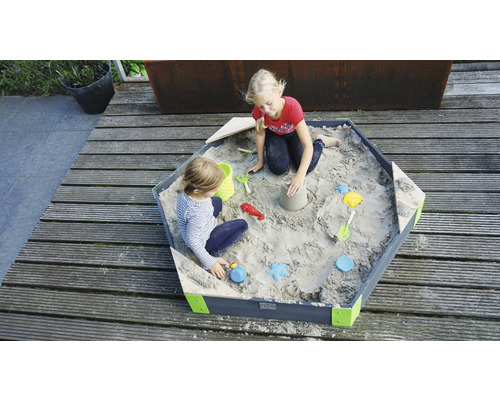 Sechseckiger Sandkasten aus Holz mit zwei spielenden Kindern und Sandspielzeug