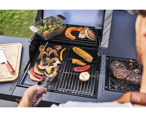 Grillszene mit Gemüse, Meeresfrüchten und Fleisch auf einem Gasgrill.