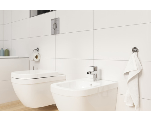 Helles Badezimmer mit Toilette, Bidet und weißen Wandfliesen