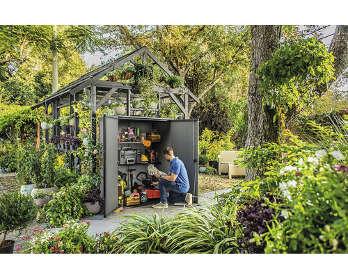 Szene mit einem Gartenschuppen, der mit Gartengeräten und Werkzeugen gefüllt ist, umgeben von üppigem Grün
