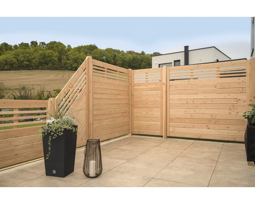 Terrasse mit Sichtschutzzaun aus Holz, Pflanzkübel und Windlicht