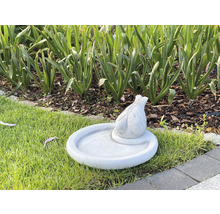 Vogeltränke mit Vogel-Figur im Garten