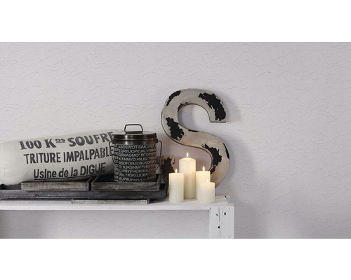Dekorative Szene mit Kissen, Behälter, Kerzen und Buchstabe auf einem Regal