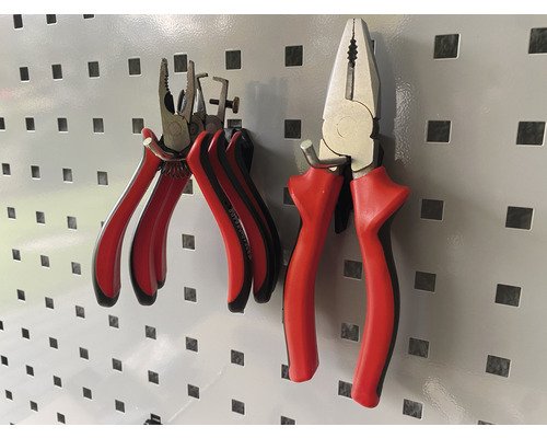 Zwei Zangen mit Griffen hängen an einer Lochwand.