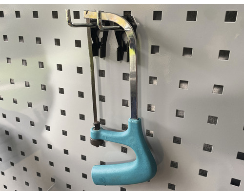 Bügelsäge mit Kunststoffgriff an einer Lochwand