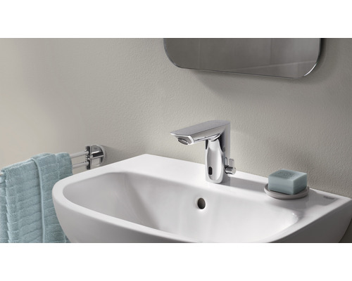 Aufnahme eines Badezimmers mit Waschbecken, Armatur, Handtuch und Spiegel.