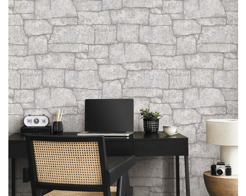 Büro mit Steintapete, Schreibtisch, Laptop und Bürostuhl