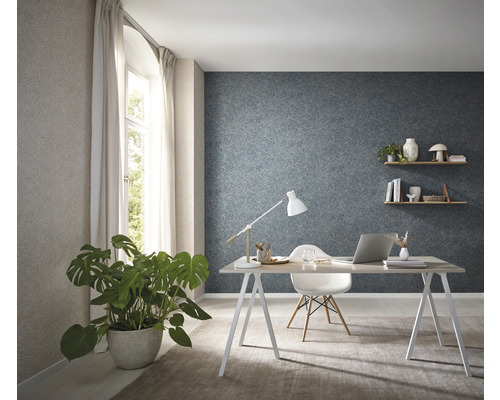 Helles Arbeitszimmer mit Schreibtisch, Stuhl, Zimmerpflanze und gemusterter Tapete