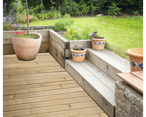 Gartenszene mit Holzterrasse, Holzstufen und bepflanzten Tontöpfen
