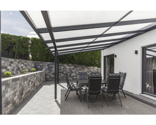 Terrasse mit Überdachung, Tisch und Stühlen an einem sonnigen Tag.