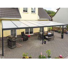 Terrassenüberdachung mit Sitzgruppe, Grill und Liegestuhl im Garten.