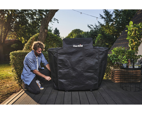 Mann befestigt eine Grillabdeckung der Marke Char-Broil auf einer Terrasse