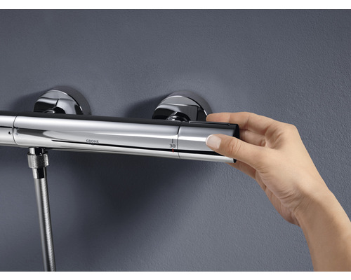 Grohe Duscharmatur mit Thermostat und Hand die Temperatur einstellt