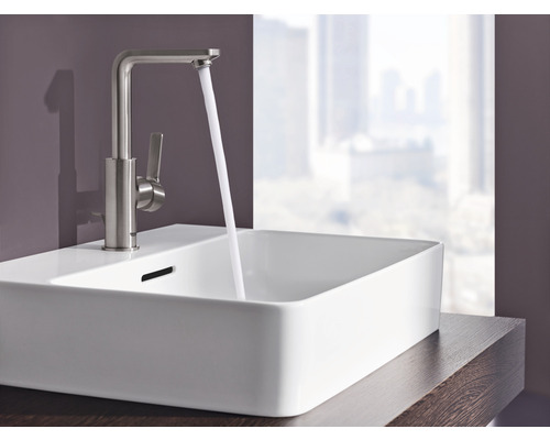 Waschtisch mit Armatur und fließendem Wasser in einem Badezimmer.