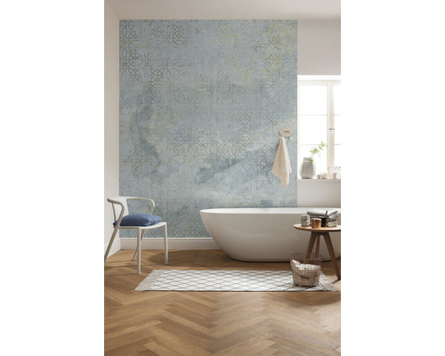 Badezimmer mit Badewanne, Stuhl, Teppich, Hocker und gemusterter Tapete.