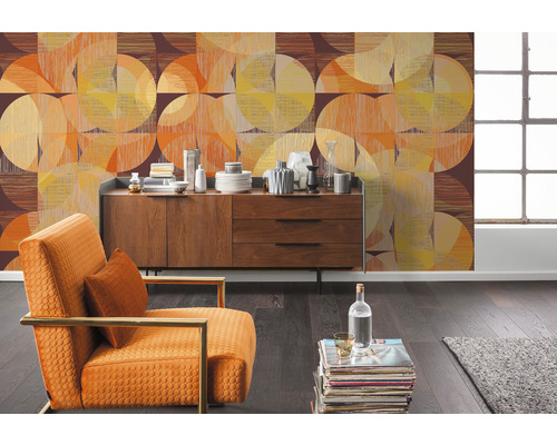 Wohnzimmer mit gemusterter Tapete, Kommode und Sessel