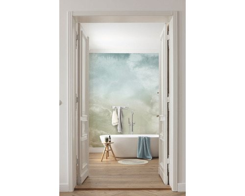 Helles Badezimmer mit Badewanne, Hocker und Wolkenmuster-Tapete, Blick durch eine offene Tür.