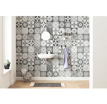 Badezimmer mit Waschbecken, Spiegel, Regal und Wandfliesen mit Ornamentmuster