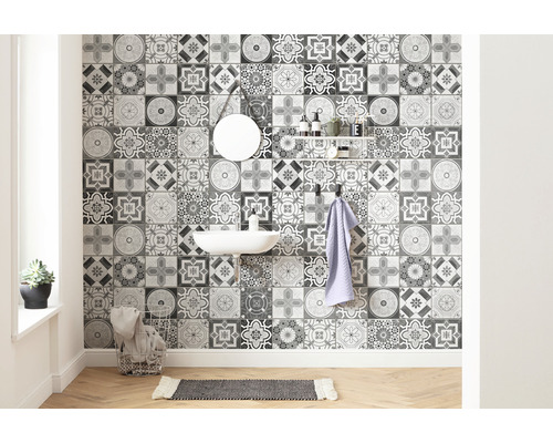 Badezimmer mit Waschbecken, Spiegel, Regal und Wandfliesen mit Ornamentmuster