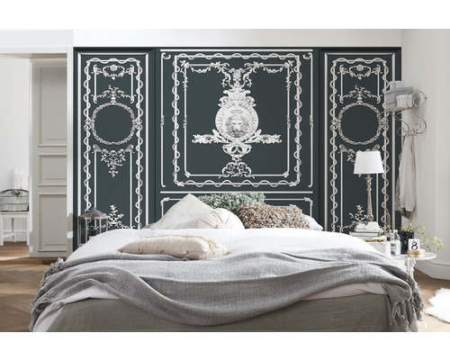 Schlafzimmer mit Bett, Decken, Kissen und Wandpaneelen mit Zierleisten