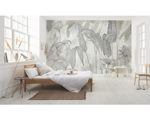 Helles Schlafzimmer mit einem Bett und einer Wandtapete mit Pflanzenmotiven