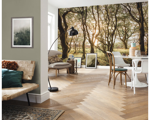 Wohnraum mit Fototapete eines Waldes, Sofa, Sessel, Tisch und Parkettboden