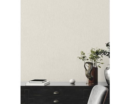 Nahaufnahme einer Wand mit Textiltapete in einem hellen Farbton, die ein strukturiertes Erscheinungsbild bietet.