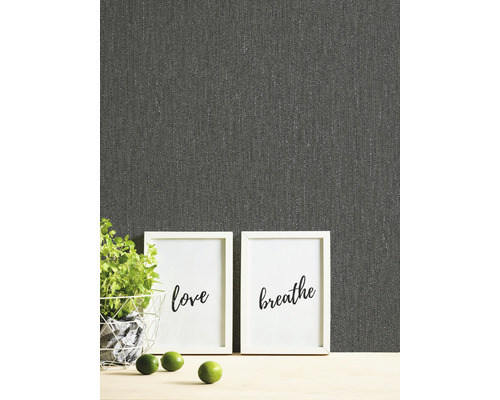 Nahaufnahme einer grauen Textiltapete mit den Worten Liebe und Atmen in Bilderrahmen, Topfpflanze und Limetten