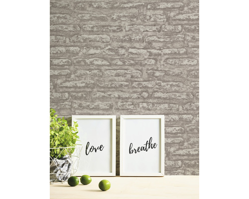 Wohnszene mit Mauerwerk Tapete, Topfpflanze und gerahmten Postern