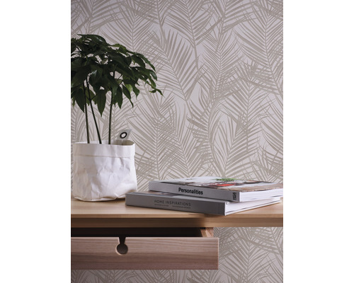 Dekorative Tapete mit Palmenmuster im Wohnraum mit Tisch und Pflanze.