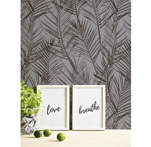 Dekorative Tapete mit Palmenblattmuster, kombiniert mit minimalistischen Wandbildern für eine moderne Raumgestaltung.