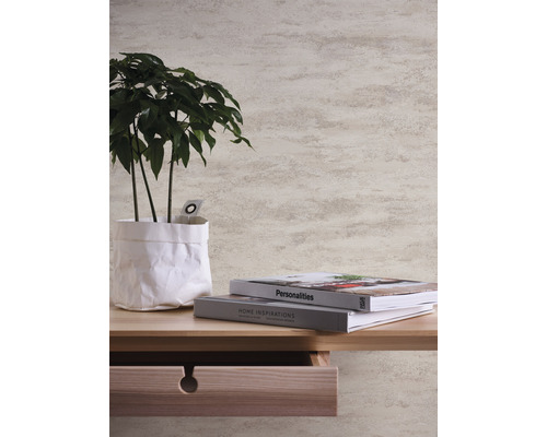 Nahaufnahme einer Wand mit Tapete, einem Holztisch mit Pflanze und Büchern