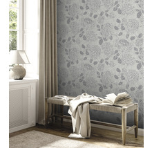Raumansicht mit floral gemusterter Tapete, Bank und Fenster.