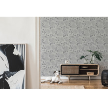 Wohnzimmer mit floral gemusterter Tapete, Kommode und Hund