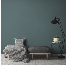 Wohnzimmer mit Sessel, Hocker, Stehlampe und Dekoration