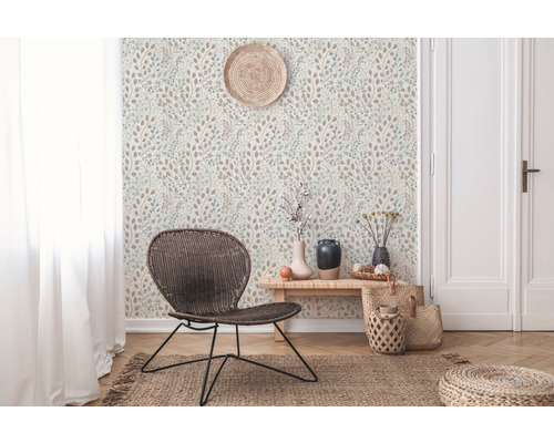 Wohnraum mit gemusterter Tapete, Rattan-Sessel und dekorativen Accessoires für ein gemütliches Ambiente