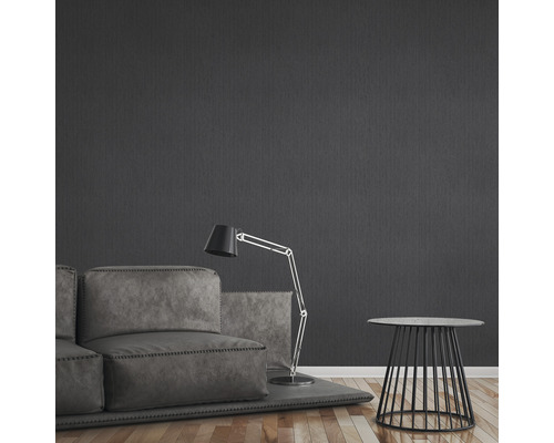 Wohnzimmer mit Sofa, Stehlampe und Beistelltisch vor dunkler Wand