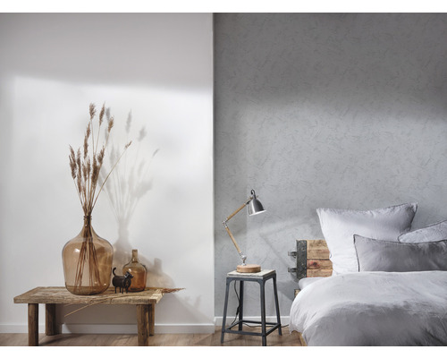 Helles Schlafzimmer mit einem Bett, einer Lampe und dekorativen Elementen auf einem Holztisch