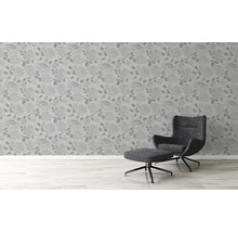 Raumansicht mit Blumentapete und Sessel mit Hocker