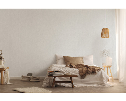 Helles Schlafzimmer mit Texturtapete, Bett und Holzelementen.
