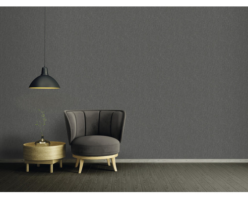 Wohnzimmer mit grauer Strukturtapete, Sessel, Beistelltisch und Pendelleuchte
