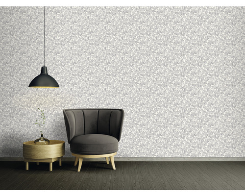 Wohnzimmer mit gemusterter Tapete, Sessel, Beistelltisch und Hängelampe