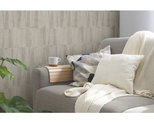 Wohnzimmer mit grauer Couch, Kissen und gemusterter Tapete