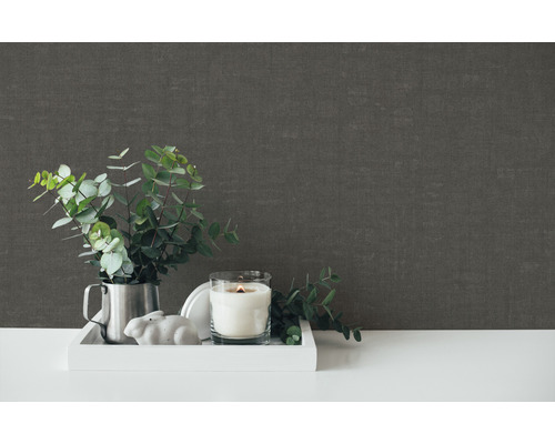 Dekorative Szene mit Kerze, Pflanze und grauer Wandtapete