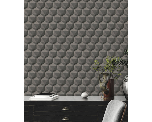 Innenraum mit dunklem Schreibtisch vor einer Wand mit geometrischer Tapete