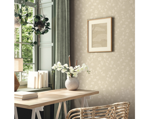Ein Zimmer mit einem Schreibtisch, einer Vase mit Blumen, einem Bild an der Wand und einer gemusterten Tapete