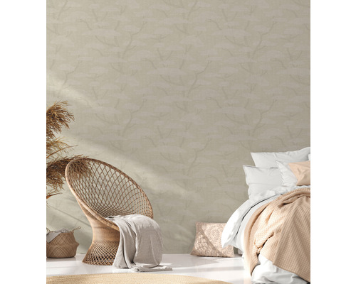 Schlafzimmer mit Rattansessel, Bett und gemusterter Tapete für eine helle, freundliche Atmosphäre.
